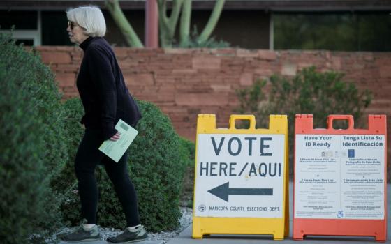 A voter carries a ballot to a polling place in Phoenix as Arizona's Democratic and Republican parties held primary elections on March 19. 