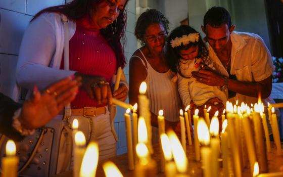 Devotees light candles at shrine of the Virgin of Charity in El Cobre, Cuba. 
