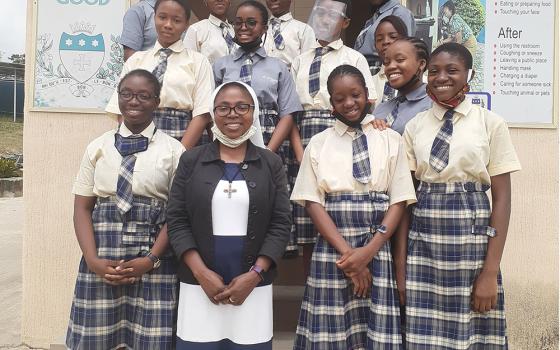 Sr. Teresa Anyabuike, a member of the African Faith and Justice Network, bottom middle, poses with students after a seminar about child abuse and human trafficking in Abuja, Nigeria. Sr. Eucharia Madueke writes that GSR has made the AFJN's Women Empowerment Project credible to the public and inspired sisters within and outside Africa. (CNS/Courtesy of Sr. Eucharia Madueke)