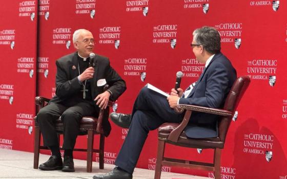 El Paso Bishop Mark Seitz, left, talks with Peter K. Kilpatrick, president of The Catholic University of America, during a daylong conference on immigration the university hosted with the U.S. Conference of Catholic Bishops April 11 in Washington.