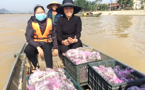 Srs. Anna Nguyen Thi Hong (left) and Anna Nguyen Thi Bich Nguyet travel by boat to give food to flood victims in areas of Vietnam in November.