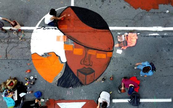 Climate change activists in San Francisco paint a mural during a protest outside of BlackRock headquarters Oct. 29, 2021, ahead of the 2021 U.N. Climate Change Conference. (CNS/Reuters/Nathan Frandino)