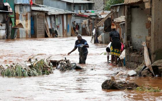 Residents wade through flood waters as they recover their belongings in the Mathare Valley settlement of Nairobi, Kenya, April 24, after the Nairobi River burst its bank. 
