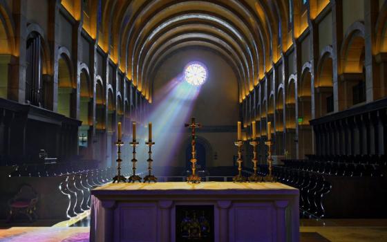 Light shines through small window into dark church.