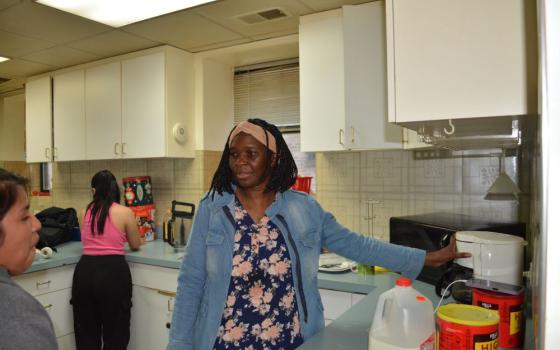 Franciscana Clarisa Sr. Stella Akello, intake officer at Bethany House of Hospitality in Chicago, gives a newly arrived Guatemalan woman a lesson in using the coffeemaker May 7. 
