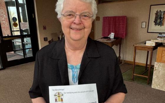 Benedictine Sr. Mary Elizabeth Schweiger holds a petition against mining in El Salvador March 24 signed by women religious at Mount St. Scholastica monastery in Atchison, Kansas. The Benedictines joined the Sisters of Charity in nearby Leavenworth as well as other Catholics from Kansas showing solidarity with the Catholic Church in El Salvador fighting a new law that allows metal mining. (GSR photo/Rhina Guidos) 