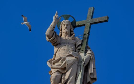 The statue of the Risen Christ on top of the facade of St. Peter's Basilica at the Vatican 