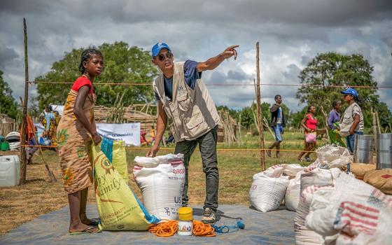 A Catholic Relief Services worker is pictured in a file photo helping a young woman at a food distribution area in Marojela village, located in the Marolinta commune in southern Madagascar's Beloha District. (OSV News/Courtesy of Catholic Relief Services/Jim Stipe)