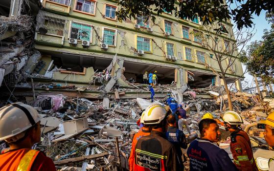 Rescuers work at the site of a damaged building in Mandalay, Myanmar, March 30, in the aftermath of a strong earthquake that struck two days earlier. People in Myanmar are in desperate need of humanitarian supplies and medical support as the death toll from the devastating earthquake that rocked central Myanmar continues to rise. (OSV News/Reuters)