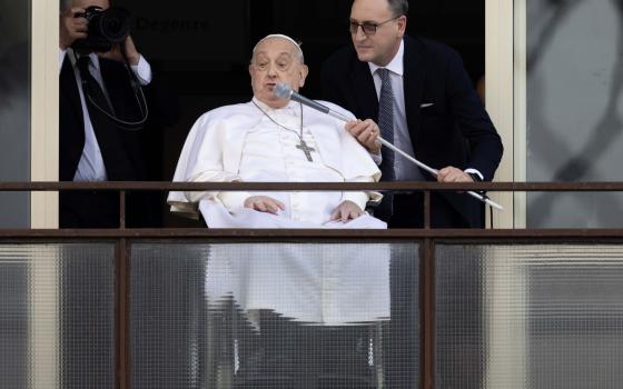 Massimiliano Strappetti, the nurse who is Pope Francis' primary medical caregiver at the Vatican, adjusts a microphone for the pope as he greets a crowd of well-wishers at Rome's Gemelli hospital before returning to the Vatican March 23, 2025. Pope Francis, formerly Argentine Cardinal Jorge Mario Bergoglio, died April 21 at age 88. (CNS photo/Pablo Esparza)