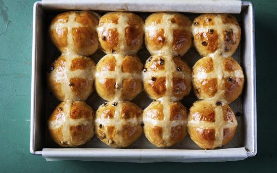 This image released by Milk Street shows a recipe for hot cross buns studded with bourbon-plumped currants. (Milk Street via AP)