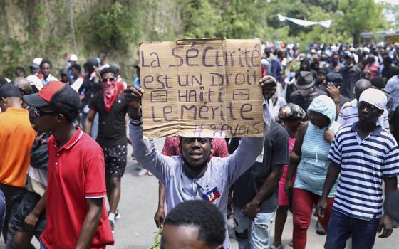 A protester holds up a sign that reads in French, "Security is a right, Haiti deserves it" during a protest against insecurity April 2 in Port-au-Prince, Haiti. Two women religious, Sr. Evanette Onesaire and Sr. Jeanne Siliane Voltaire, were killed March 31. (AP photo/Odelyn Joseph)