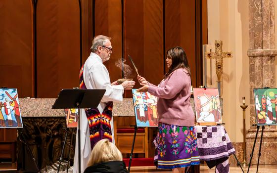 Deacon Bill Frere and Jody Roy, both of the St. Kateri Center of Chicago, conduct a smudging ceremony with an eagle feather and sage in Holy Name Cathedral in Chicago, prior to an April 11 Stations of the Cross centered on Native Americans. The devotion's prayers, composed by a permanent deacon with Indigenous ancestry, meditate on the suffering of Native people while calling for the faithful to stand in solidarity and work for justice. (Courtesy of Jade Roy)