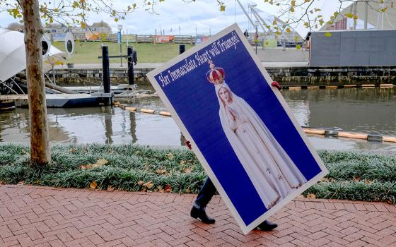 A protester carries a placard Nov. 13, 2018, for a rally sponsored by Church Militant in Baltimore. (CNS/Tennessee Register/Rick Musacchio)
