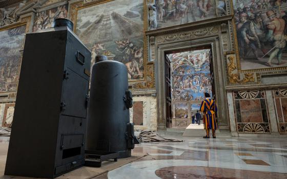 The stove that will be used to burn ballots during the conclave to elect a new pope in the Sistine Chapel and the machine that adds chemicals to create dark black or bright white smoke are seen at the Vatican May 2, 2025. Cardinals under the age of 80 will enter the conclave May 7. (CNS/Vatican Media)