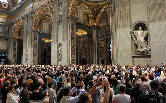 People use their phones to take photos as cardinals process into St. Peter's Basilica at the Vatican for Mass on the final day of the official mourning for Pope Francis on May 4, 2025. (CNS/Lola Gomez)