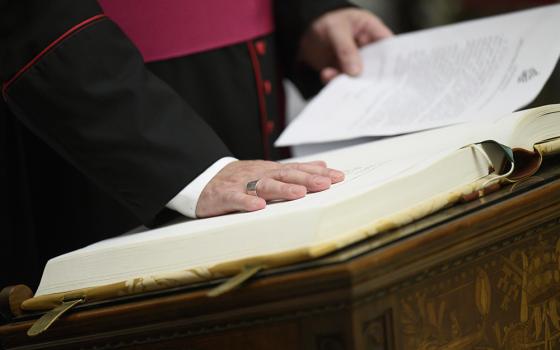 A prelate takes an oath of secrecy May 5, 2025, in preparation for the conclave at the Vatican to elect a new pope. The staff of the cardinals' residence hall, medical assistants and even the cardinals' bus driver took an oath swearing to protect the cardinals' privacy and the conclave's secrecy. (CNS/Vatican Media)