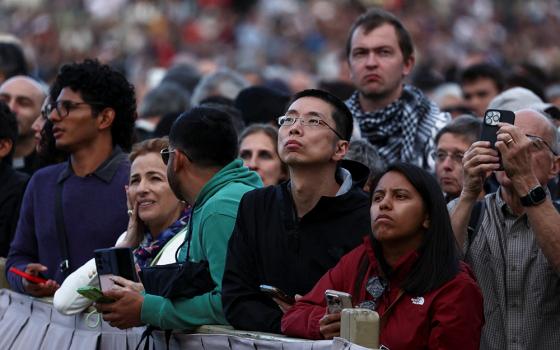 People wait for the smoke to rise from the chimney in St. Peter's Square at the Vatican on the evening of May 7, 2025, as cardinals gather in the Sistine Chapel on the first day of the conclave to elect a new pope. (OSV News/Reuters/Yara Nardi)