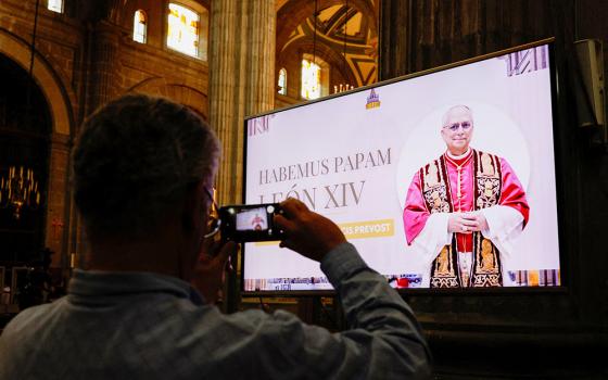 A member of the faithful holds their phone after Mass at the Metropolitan Cathedral in Mexico City, where an image of the pope was shown on screen at Zocalo Square May 8, 2025, after Cardinal Robert Prevost was announced as Pope Leo XIV. (OSV/Reuters/Henry Romero)