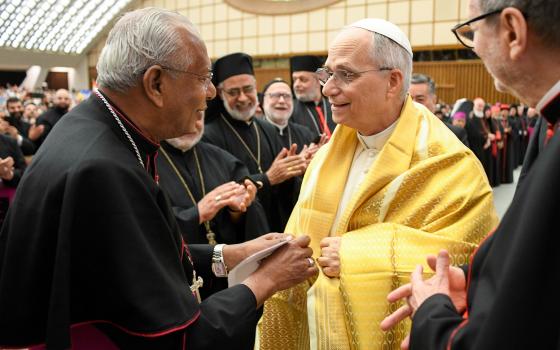  Pope Leo XIV tries on a traditional shawl as he greets participants in the Jubilee of the Eastern Churches in the Paul VI Audience Hall at the Vatican May 14, 2025. 