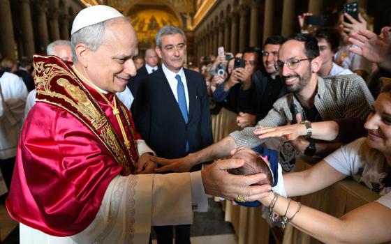 Pope Leo XIV blesses a baby as he departs following a visit to the Basilica of St. Paul Outside the Walls in Rome May 20, 2025. (CNS/Vatican Media)