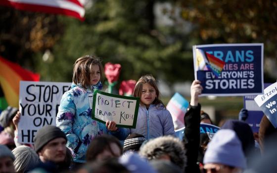 People hold signs as the U.S. Supreme Court hears arguments over an appeal by then-U.S. President Joe Biden's administration of a lower court's decision upholding a Republican-backed ban in Tennessee on gender-affirming medical care for transgender minors, in Washington Dec. 4, 2024. The nation's highest court on June 18, 2025, upheld the Tennessee state law. (OSV News photo/Benoit Tessier, Reuters)