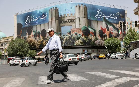A man walks next to an anti-Israel billboard on a street in Tehran, Iran, June 24, 2025. President Donald Trump announced on social media June 23 that Israel and Iran reached a ceasefire agreement after 12 days of war, however both sides accused the other of violations in the hours afterward. (OSV News/West Asia News Agency via Reuters/Majid Asgaripour)