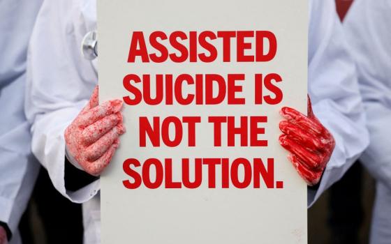 A protester holds a placard outside the Parliament in London Nov. 29, 2024, as British lawmakers debate a physician-assisted suicide bill. The House of Commons passed the bill 314 to 291 on June 20. The measure now proceeds to a debate and vote in the House of Lords. (OSV News/Reuters/Mina Kim)