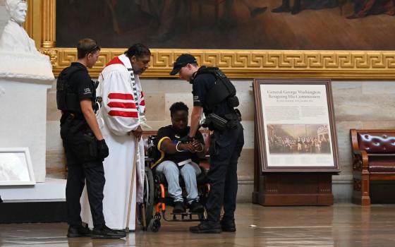 Police arrest the Rev. William Barber II, center left, and Suvya Carroll, center right, in the U.S. Capitol Rotunda June 2 in Washington. Nine people arrested were charged with "crowding, obstructing and incommoding." (RNS photo/Jack Jenkins)