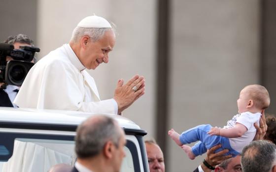 Pope Leo greets a child.