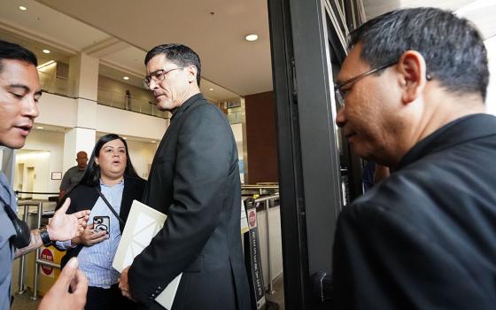 San Diego Bishop-designate Michael Pham follows Jesuit Fr. Scott Santarosa into the Edward J. Schwartz Federal Building on Friday morning, June 20, in downtown San Diego. (Chris Stone)