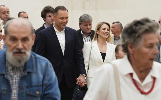 Presidential candidate Karol Nawrocki, center left, arrives at a polling station with his wife Marta Nawrocka, center right, during the presidential election runoff in Warsaw, Poland, June 1, 2025. (AP/Czarek Sokolowski)