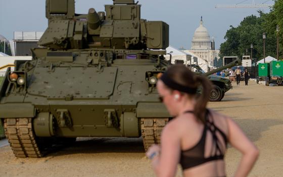 People pass by a tank, parked on the National Mall, during preparations for an upcoming military parade commemorating the Army's 250th anniversary and coinciding with President Donald Trump's 79th birthday, Thursday, June 12, 2025, in Washington. (AP photo/Rod Lamkey, Jr.)
