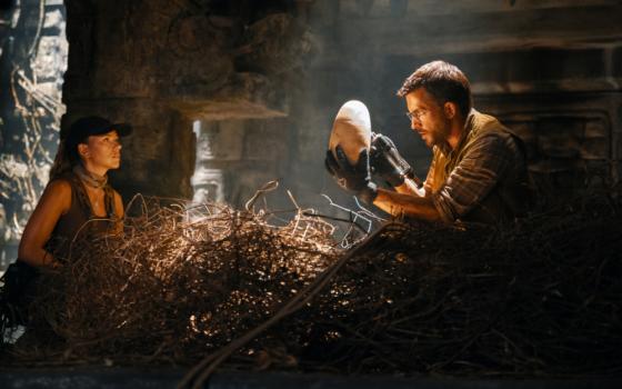 Scarlett Johansson looking at Jonathan Bailey holding an egg in "Jurassic World: Rebirth." (Universal Pictures)