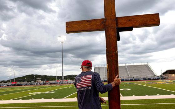 A man holds a cross during a prayer service for flood victims in Kerrville, Texas, July 9, 2025. (OSV News/Reuters/Umit Bektas)