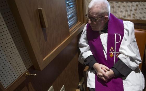 A priest hears confession.