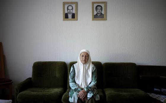 Fadila Efendic, 74, sits in her living room backdropped by the pictures of her son and husband, victims of the Srebrenica genocide in the village of Potocari near Srebrenica, Bosnia, on June 28. During the July 1995 genocide a total of 22 members of her family were killed. (AP/Armin Durgut)