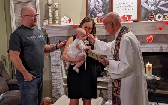 Phil Marcin is shown baptizing his grandson Declan, held by his mom, Maggie and alongside his dad, Phillip, in 2021. (Courtesy of Phil and Linda Marcin)