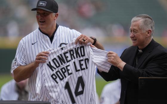 Cardinal Blase Cupich, right, presents former White Sox player Paul Konerko with a jersey signed by Pope Leo XIV during a ceremony honoring the 2005 World Series Champions before a baseball game between the Cleveland Guardians and Chicago White Sox, Saturday, July 12, 2025, in Chicago. (AP Photo/Erin Hooley)