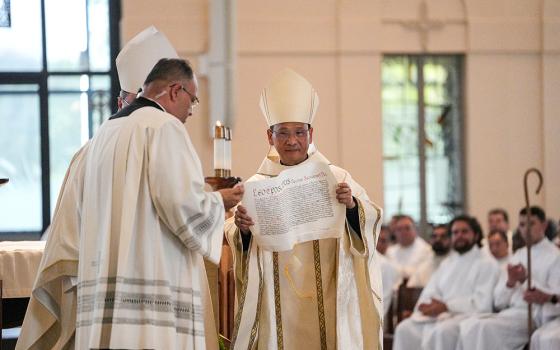 Bishop Michael Pham receives the apostolic mandate from Pope Leo XIV at the Mass installing him as head of the San Diego Diocese on July 17, 2025, at St. Thérèse of Carmel Parish in San Diego. (NCR photo/Chris Stone)