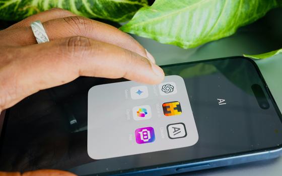A hand hovers over a cellphone, about to tap the icon for ChatGPT. (Unsplash/Solen Feyissa)