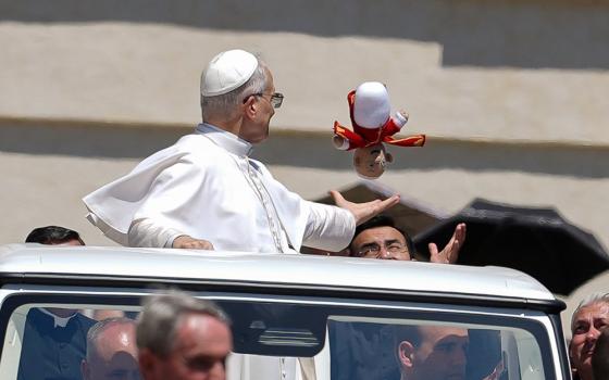 Pope Leo XIV catches a crocheted Pope Leo doll tossed to him as he rode in the popemobile around St. Peter's Square at the Vatican May 28, 2025. (CNS/Lola Gomez)