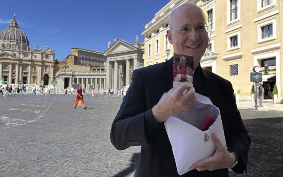Rev. James Martin, a New York-based Jesuit, shows a commemorative photograph of Pope Leo XIV during an interview with The Associated press just outside St. Peter's Square in Rome, Monday, Sept. 1, 2025. (AP Photo/Maria Selene Clemente)