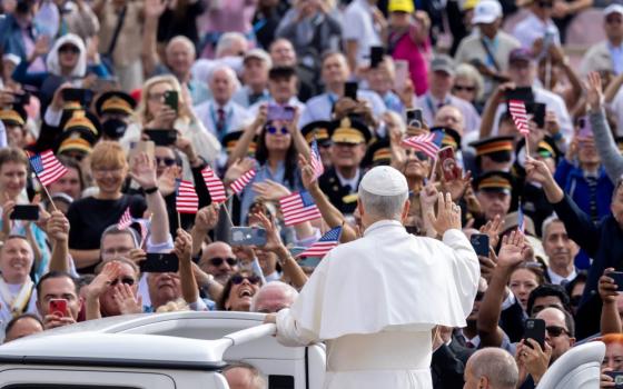 Pope Leo XIV greets visitors and pilgrims from the popemobile before his weekly general audience, with people waving US flags,in St. Peter's Square at the Vatican Oct. 1. (CNS/Pablo Esparza)
