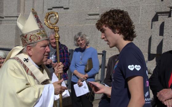 Archbishop Bernard Hebda of St. Paul and Minneapolis accepts a letter Jimmy Kaiser wrote to Pope Leo XIV thanking the pontiff for his prayers for the Annunciation community in Minneapolis. Hebda delivered letters from students and families at Annunciation to Pope Leo Oct. 1 at the Vatican. (OSV News photo/Tom Halden, courtesy Archdiocese of St. Paul and Minneapolis)