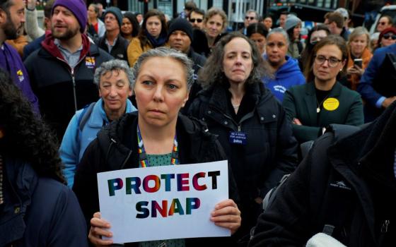 A woman holds a sign during "A Rally for SNAP" on the steps of the Massachusetts Statehouse in Boston Oct. 28 ahead of the anticipated suspension of food aid benefits Nov. 1 amid the ongoing U.S. government shutdown. (OSV News/Brian Snyder, Reuters)
