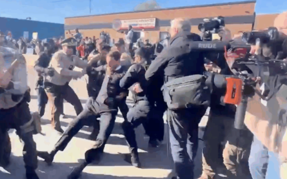 The Rev. Michael Woolf, center, is pulled from a group of demonstrators by police officers outside the U.S. Immigration and Customs Enforcement detention facility in Broadview, Illinois, Nov. 14.