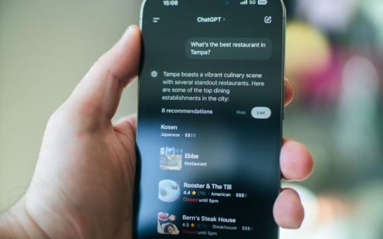 Hand holds cellphone that shows ChatGPT search.