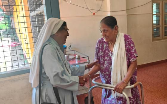 Queen of the Apostles Sr. Melania D'Souza comforts a senior citizen in the palliative care unit of Goretti Hospital in Udupi, a coastal town in the southwestern Indian state of Karnataka. (Thomas Scaria)