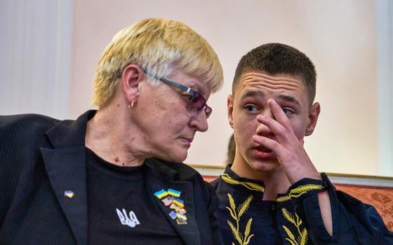 Liudmyla Siryk, left, listens to her grandson, Oleksandr Radchuk, during a press conference on the return of Ukrainian children and civilians taken by Russia during the three-and-a-half-year war, at the Embassy of Ukraine in Italy, in Rome Nov. 19, 2025. (AP/Domenico Stinellis)